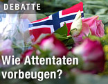 Eine kleine norwegische Fahne liegt zwischen Blumen
