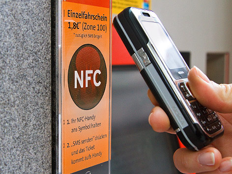 Eine Hand hält ein Handy an ein NFC-Terminal der Wiener Linien.