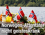 Norwegische Flaggen und Kerzen vor der Insel Utoya