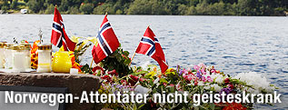 Norwegische Flaggen und Kerzen vor der Insel Utoya