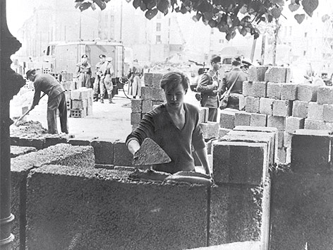 © dapd Arbeiter mauern die ersten Steinblöcke der Berliner Mauer.