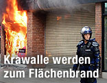 Polizistin in Manchester vor einem brennenden Schaufenster