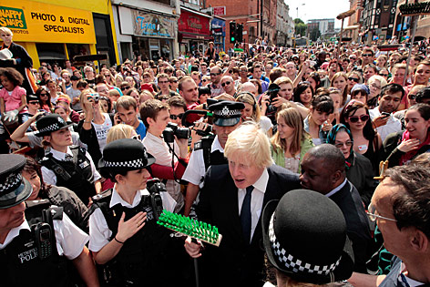 Londons Bürgermeister Johnson steht mit einem Besen in einer Menschenmenge