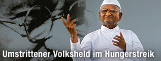 Der indische Bürgerrechtler Anna Hazare vor Transparant von Mahatma Gandhi