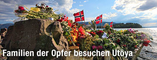 Flaggen und Blumen vor der norwegischen Insel Utöya