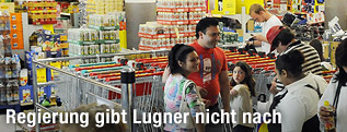 Menschen stehen vor einem Supermarkt
