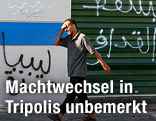 Ein Mann geht an einer mit Graffiti besprühten Wand vorbei
