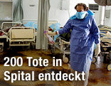 Ein Mann steht in einem verwahrlosten Raum eines Krankenhauses