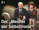 Evelyn Hamann und Loriot, mit bürgerlichem Namen Vicco von Bülow, sitzen auf dem berühmten Gründerzeitsofa aus den gemeinsamen Fernsehsketchen