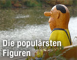 Eine lebensgroße Knollennasenfigur des Komikers Loriot sitzt auf einer Bank an der Havel in Brandenburg