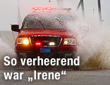 Feuerwehrwagen fährt auf einer überschwemmten Straße