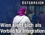 Frau mit Kppftuch geht in Einkaufsstraße