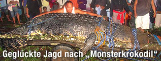 Einwohner stehen vor einem riesigen Krokodil
