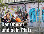 Junge Menschen sitzen auf Bänken am Yppenplatz