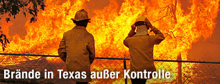 Zwei Feuerwehrmänner vor riesigen Flammen