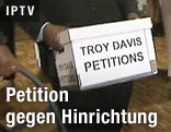 Person hält einen Karton mit der Aufschrift "Troy Davis Petitions"