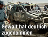 Afghanischer Polizist bei zerbombten Auto