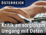 Person tippt auf einer Tastatur und bedient eine Maus
