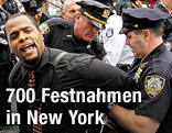 Mann wird von Polizisten auf der Brooklyn Bridge abgeführt