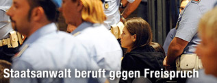 Amanda Knox umgeben von Polizeibeamten