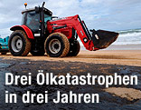 Ein Bagger entfernt Öl von einem Strand.