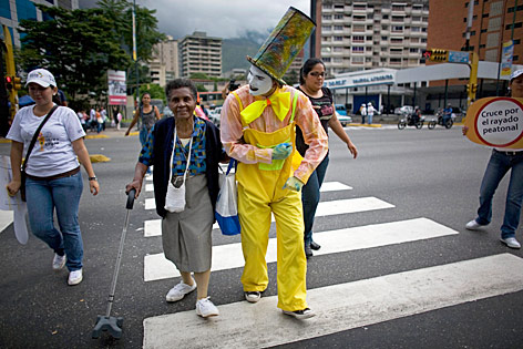 © AP/Ariana Cubillos Clown hilft Menschen über die Straße