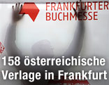 Mann hängt ein Plakat auf der Frankfurter Buchmesse auf