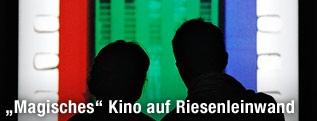 Zwei Silhouetten vor einem Kunstwerk von Tacita Dean