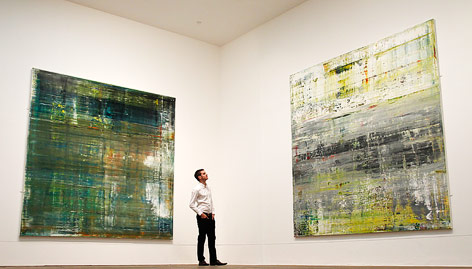 Angestellter posiert vor zwei Gemälden von Gerhard Richter