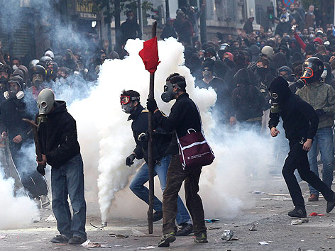 © APA/EPA/Orestis Panagiotou Griechische Demonstranten mit Gasmasken neben einer rauchenden Tränengaskartusche