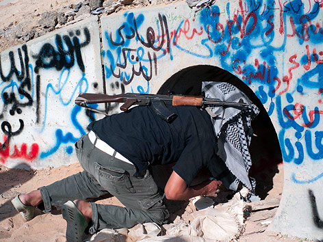 © AP/David Sperry Ein Kämpfer der libyschen Übergangsregierung kriecht in eine Tunnelröhre.