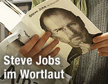 Mann liest in der Biografie von Steve Jobs
