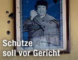 Einschusslöcher neben Bild von Gaddafi