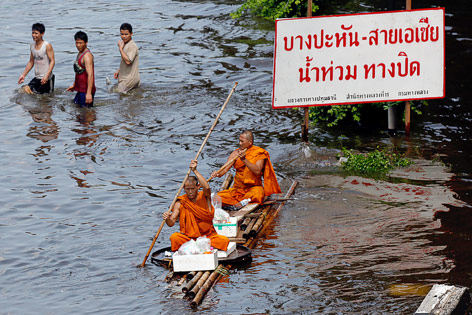 © Reuters Buddhistische Mönche paddeln durch Hochwasser in Bangkok