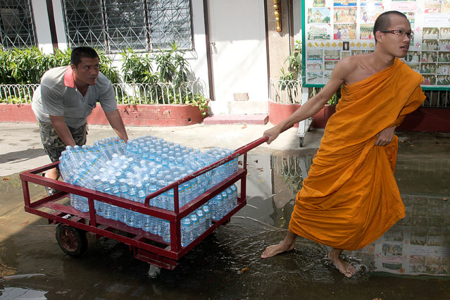 © AP/Sakchai Lalit Ein Mönch schiebt einen Transportwagen mit Trinkwasserflaschen