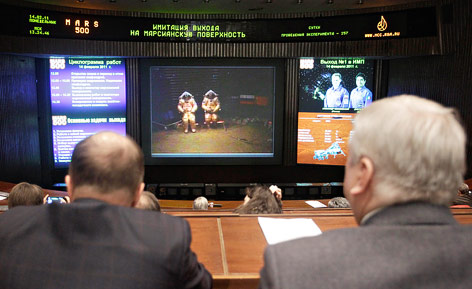 Wissenschafter beobachten in einem Kontrollraum auf Bildschirmen eine Simulation