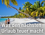Pärchen geht am Strand unter Palmen