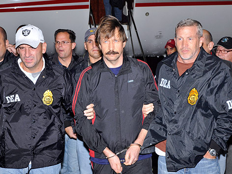 © APA/US Government Justice Department Viktor Bout mit Handschellen umringt von Sicherheitskräften bei der Ankunft in New York