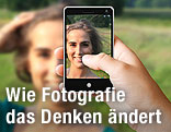 Frau wird von einem Handy fotografiert