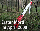Ein Polizeiabsperrband hängt am Tatort des Polizistenmordes im Siebentischwald in Augsburg an einem Baum