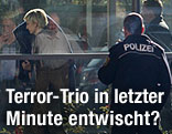 Polizisten führen mutmaßliche Täter ab