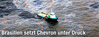 Ein Boot fährt durch einen Ölteppich.
