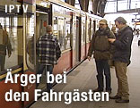 Fahrgäste stehen vor einem stehenden S-Bahn-Waggon