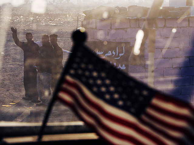 US-Flagge vor winkenden Irakern