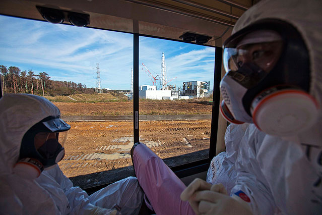 Inspektoren betrachten das zerstörte Atomkraftwerk in Fukushima durch ein Fenster