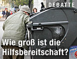 Mann blickt in eine Mülltonne