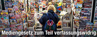 Frau steht vor einem Zeitungsstand