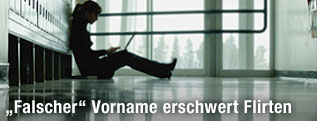 Frau mit Laptop sitzt in einem Gang