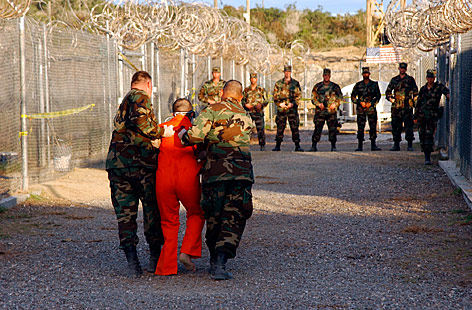 © AP/U.S. Navy/Shane T. McCoy Ein Häftling und US-Soldaten in Guantanamo