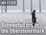 Frau geht durch verschneite Landschaft
